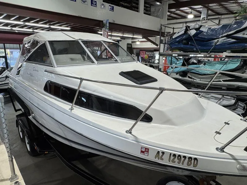Slide: The Image of 2000 Bayliner 2252 Ciera Express boat in showroom, white exterior, enclosed cabin. - 28