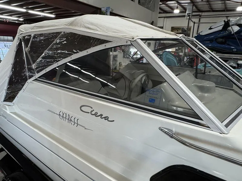 Slide: The Image of 2000 Bayliner 2252 Ciera Express boat with white canopy in a warehouse. - 32