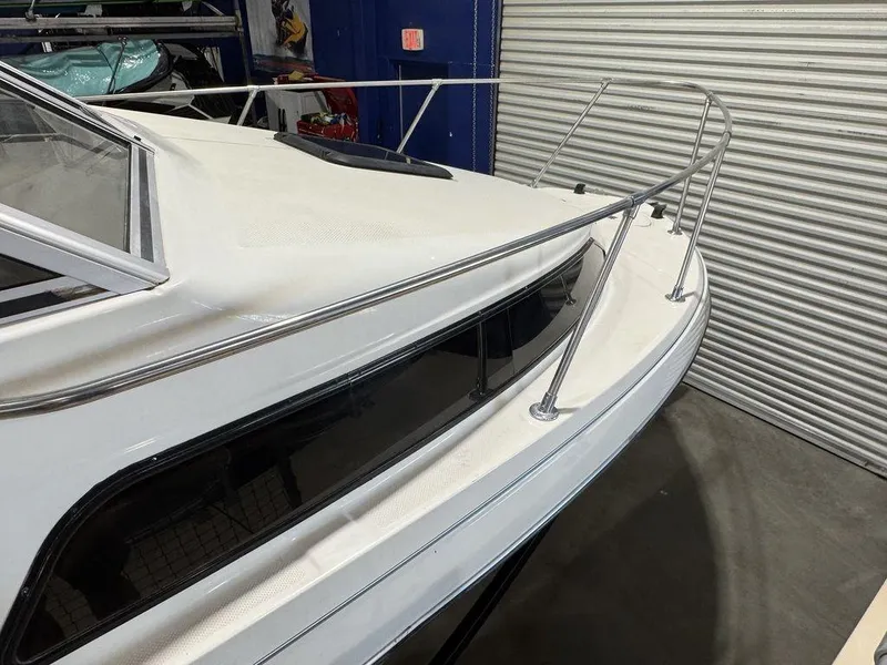 Slide: The Image of 2000 Bayliner 2252 Ciera Express boat in storage, featuring sleek white design. - 34