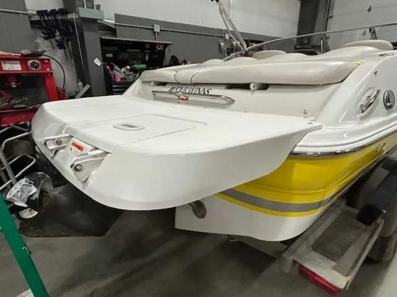 Slide: The Image of 2003 Four Winns 190 Horizon boat, yellow and white, in a garage setting. - 6