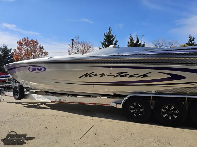 Slide: The Image of 2007 Nor-Tech 3900 Super-VEE boat on trailer, silver with purple accents, outdoors. - 23