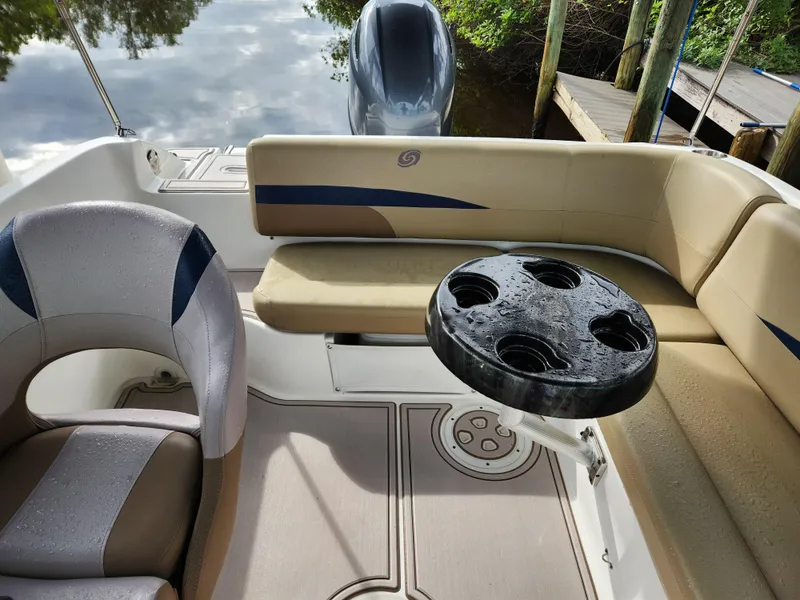 Slide: The Image of 2019 Hurricane SunDeck 187 OB interior with seating and cup holders, docked by water. - 14