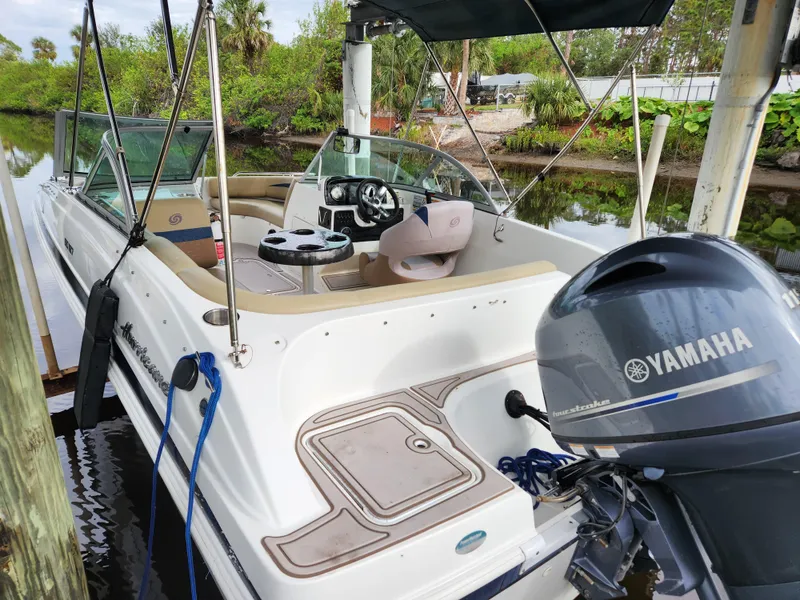 Slide: The Image of 2019 Hurricane SunDeck 187 OB boat with Yamaha outboard motor docked by lush greenery. - 4