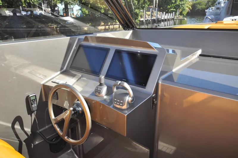 Slide: The Image of 2023 Vanquish Yachts VQ45 helm with dual screens and modern controls. - 11