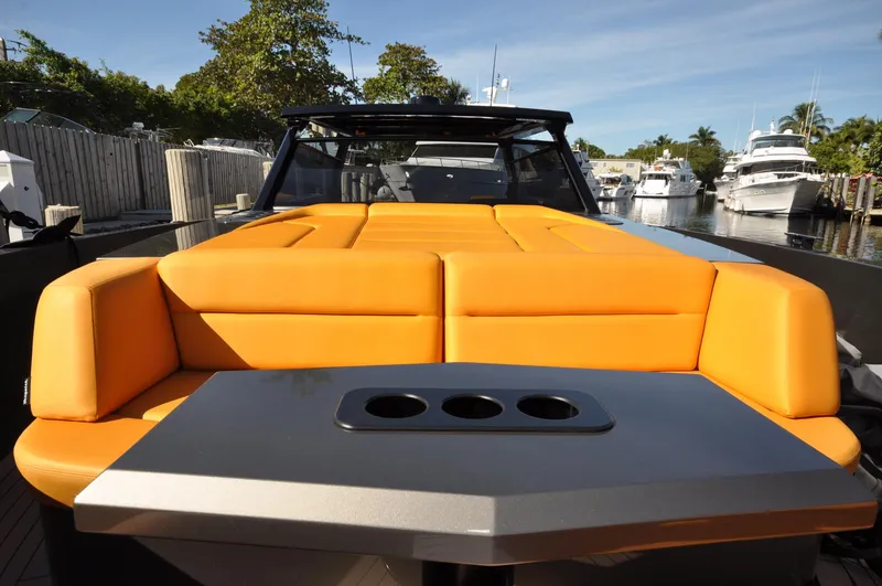 Slide: The Image of 2023 Vanquish Yachts VQ45 with orange seating, docked in a marina. - 8