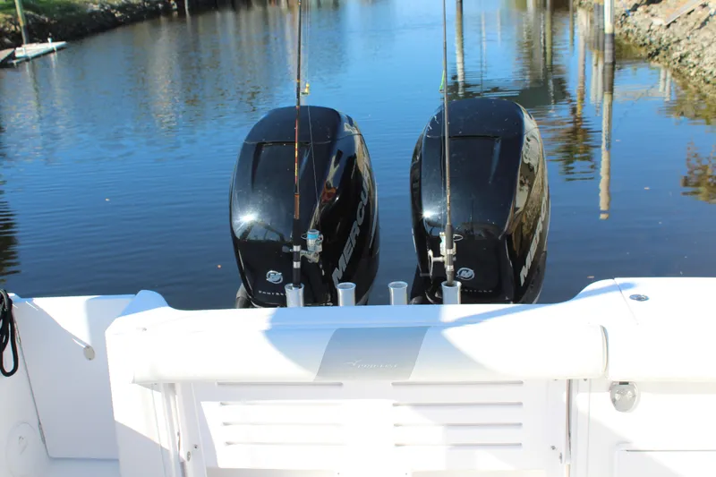 Slide: The Image of 2006 Pro-Line 32 Express boat with dual outboard motors on a calm waterway. - 10