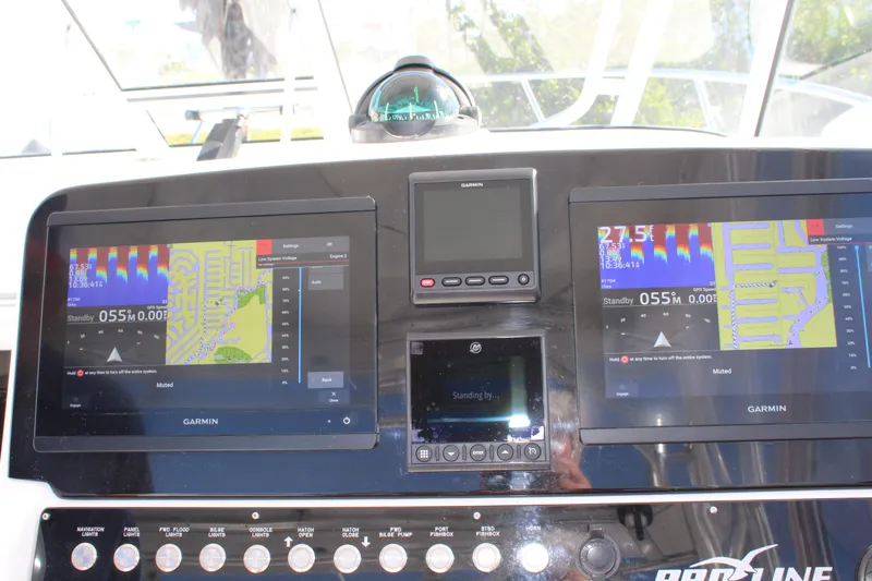 Slide: The Image of 2006 Pro-Line 32 Express boat dashboard with Garmin navigation displays. - 32