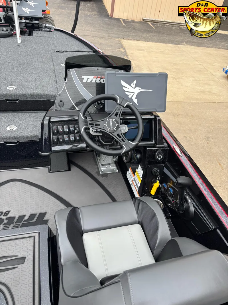 Slide: The Image of 2025 Triton 21XP boat cockpit with steering wheel and control panel. - 9