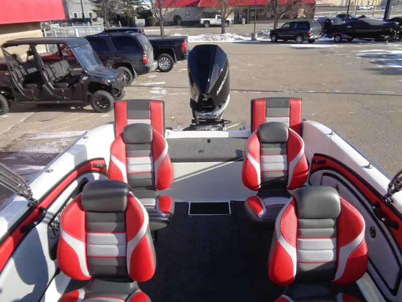 Slide: The Image of 2025 Ranger 2050MS boat interior with red and black seating, parked outdoors. - 10