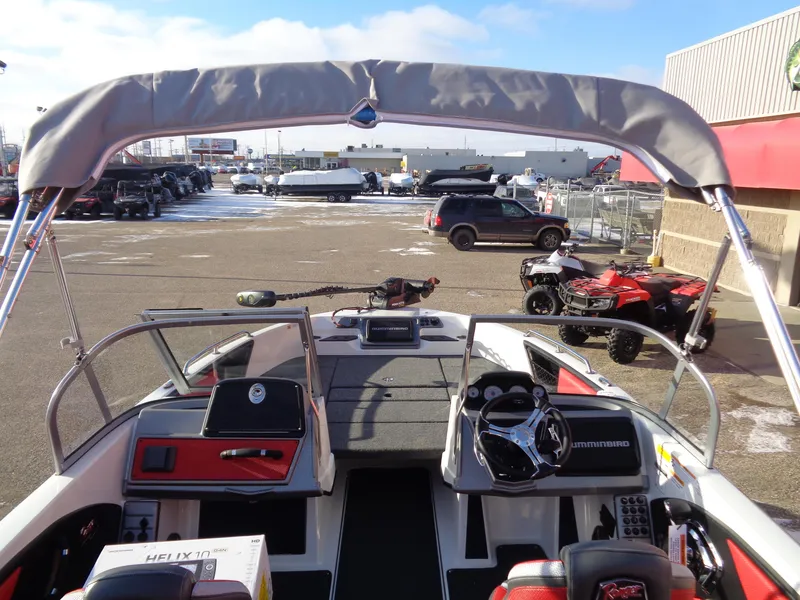 Slide: The Image of 2025 Ranger 2050MS boat interior with steering wheel and dashboard, parked outdoors. - 6