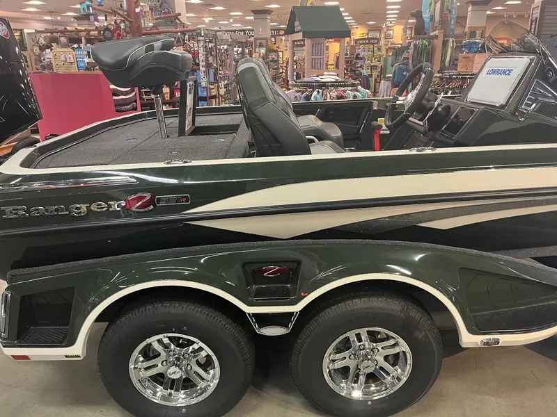 Slide: The Image of 2025 Ranger Z521R Cup-Equipped boat displayed indoors with dual-axle trailer. - 2