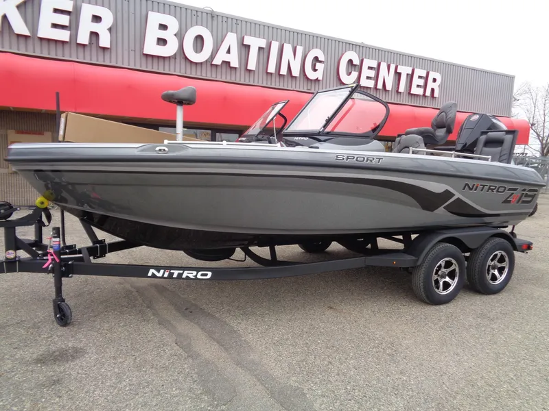 Slide: The Image of 2025 Nitro ZV19 Sport boat at dealer, gray exterior, dual-axle trailer. - 2