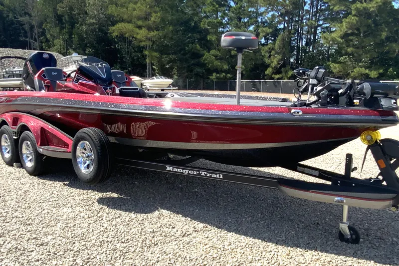 Slide: The Image of 2025 Ranger Z521R boat on trailer, parked on gravel, surrounded by trees. - 2