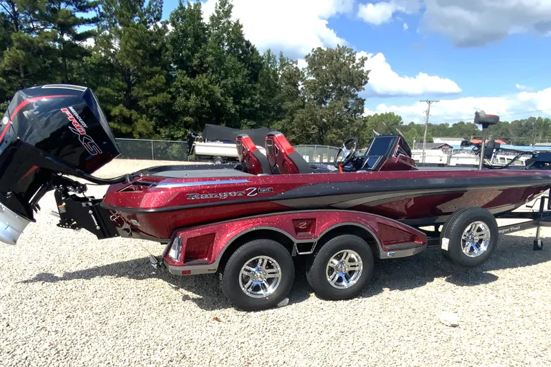 Slide: The Image of 2025 Ranger Z521R boat with trailer, parked on gravel, under a clear sky. - 3