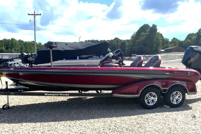 Slide: The Image of 2025 Ranger Z521R bass boat on trailer, parked outdoors under a blue sky. - 4
