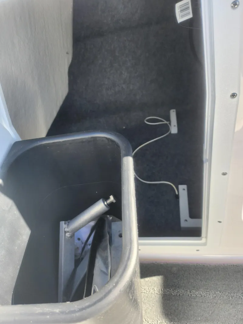 Slide: The Image of 2023 Yamaha AR190 boat interior storage compartment with black container. - 15