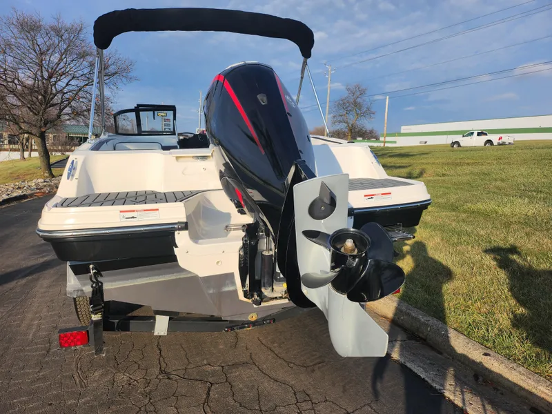 Slide: The Image of 2022 Bayliner VR4 Bowrider OB with outboard motor, parked on pavement. - 2