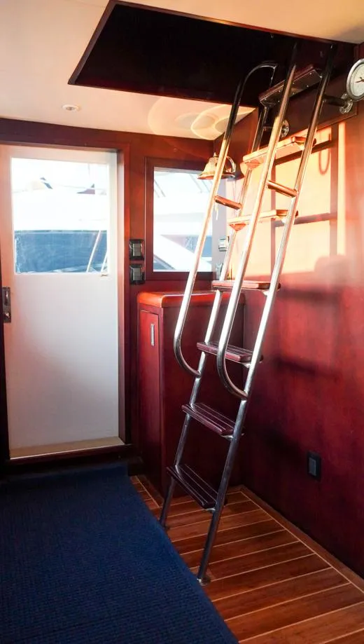 Slide: The Image of Interior of 1990 Hatteras 62 Cockpit Motor Yacht with ladder and wooden flooring. - 25