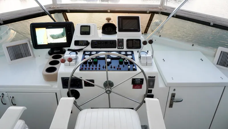 Slide: The Image of Cockpit of 1990 Hatteras 62 Cockpit Motor Yacht with steering wheel and navigation equipment. - 27