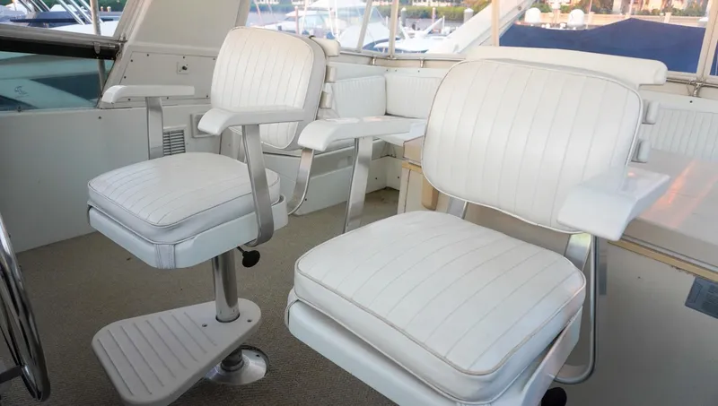 Slide: The Image of Interior of 1990 Hatteras 62 Cockpit Motor Yacht with white captain chairs. - 28