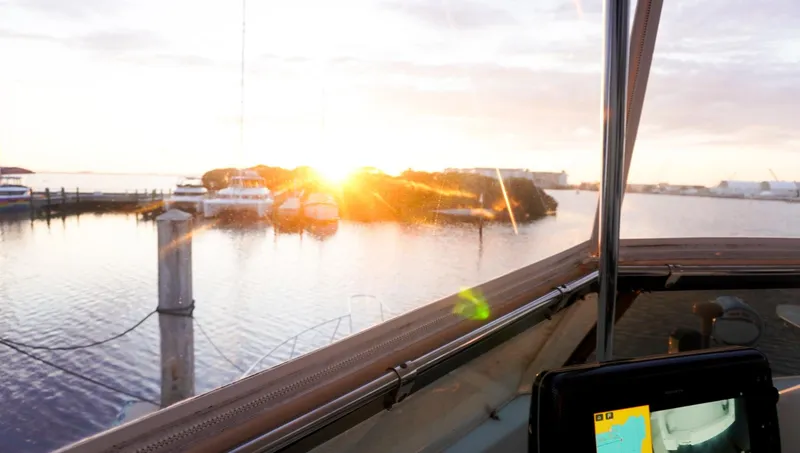 Slide: The Image of 1990 Hatteras 62 Cockpit Motor Yacht at sunset, docked with scenic water view. - 29