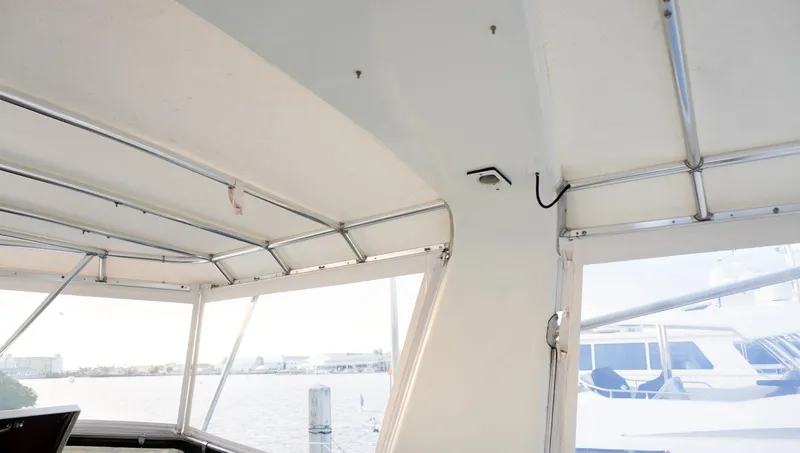 Slide: The Image of Interior view of 1990 Hatteras 62 Cockpit Motor Yacht with marina background. - 32