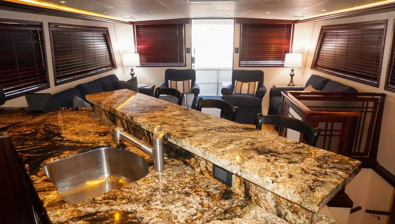 Slide: The Image of Luxurious interior of 1990 Hatteras 62 Cockpit Motor Yacht with granite countertop and plush seating. - 37