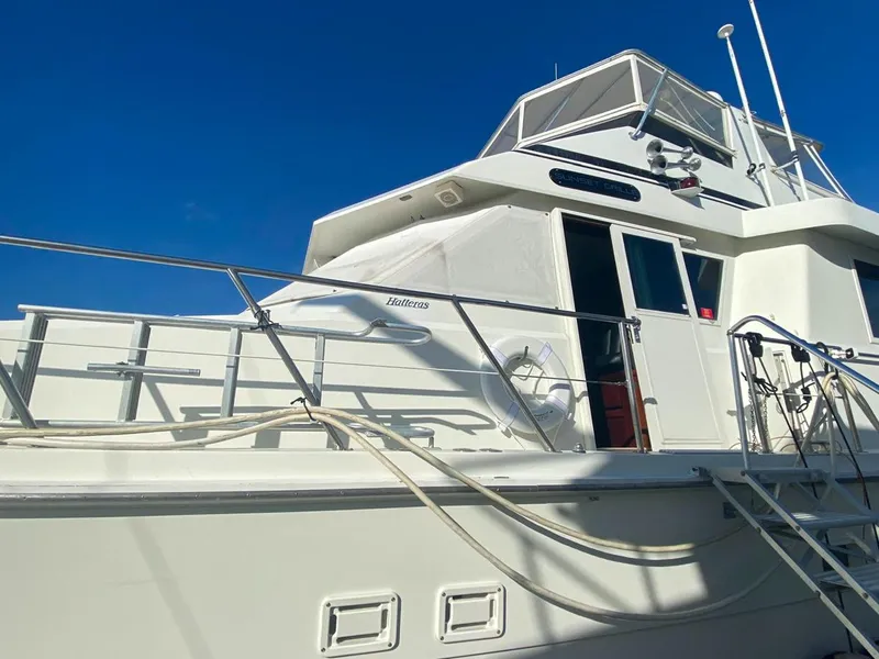 Slide: The Image of 1990 Hatteras 62 Cockpit Motor Yacht with white exterior under clear blue sky. - 4