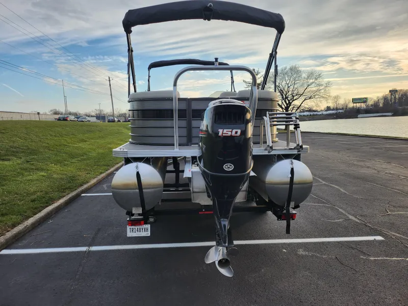 Slide: The Image of 2020 Crest Classic DLX 220 SLC pontoon boat with 150 HP motor in parking lot. - 2