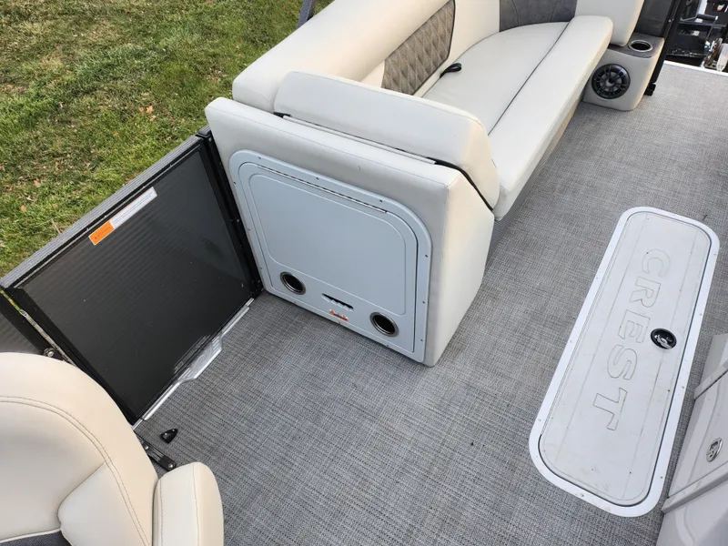Slide: The Image of 2020 Crest Classic DLX 220 SLC boat interior with plush seating and carpeted flooring. - 20