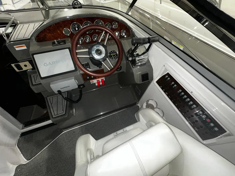 Slide: The Image of 2011 Regal 3060 Window Express boat cockpit with Garmin navigation system and wood-accented dashboard. - 18