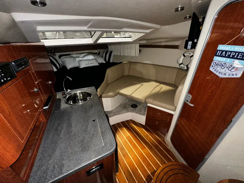 Slide: The Image of Interior of 2011 Regal 3060 Window Express boat with kitchenette and seating area. - 27