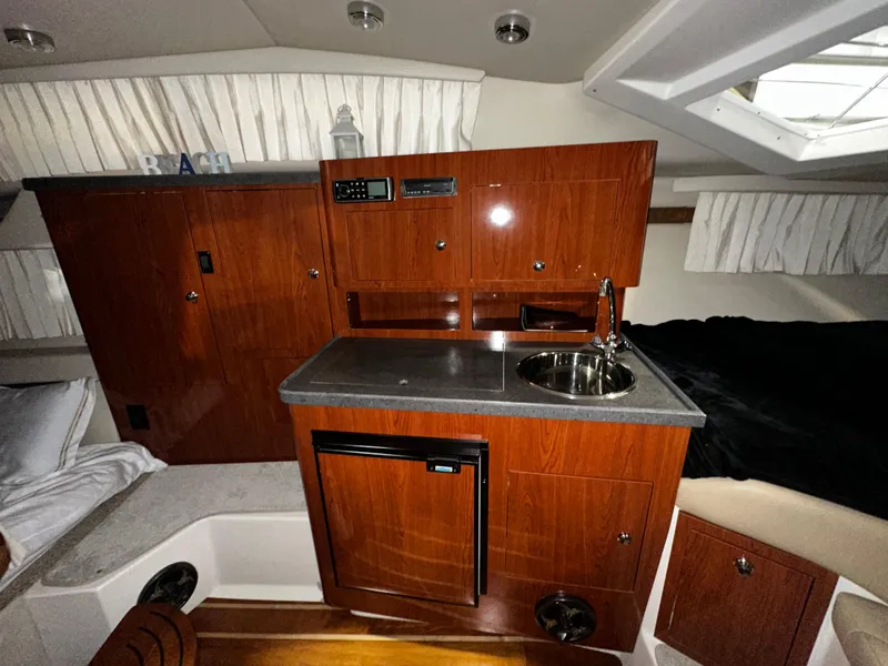 Slide: The Image of 2011 Regal 3060 Window Express cabin with kitchenette, wood cabinetry, and compact sink. - 29