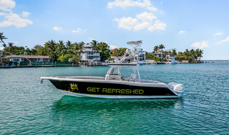 Slide: The Image of 2016 Stamas 390 Tarpon boat on water, "Get Refreshed" text on side, tropical background. - 1