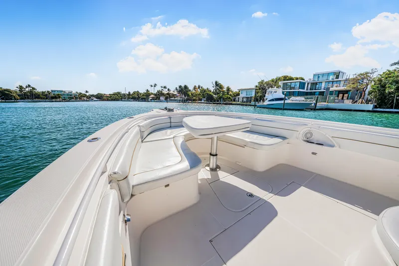 Slide: The Image of 2016 Stamas 390 Tarpon boat interior with seating and table, overlooking waterfront homes. - 24