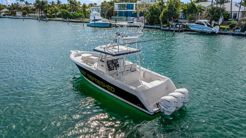 Slide: The Image of 2016 Stamas 390 Tarpon boat on calm water, featuring triple outboard engines. - 4