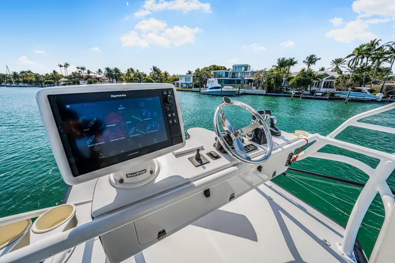 Slide: The Image of 2016 Stamas 390 Tarpon boat helm with navigation display, steering wheel, and waterfront view. - 41
