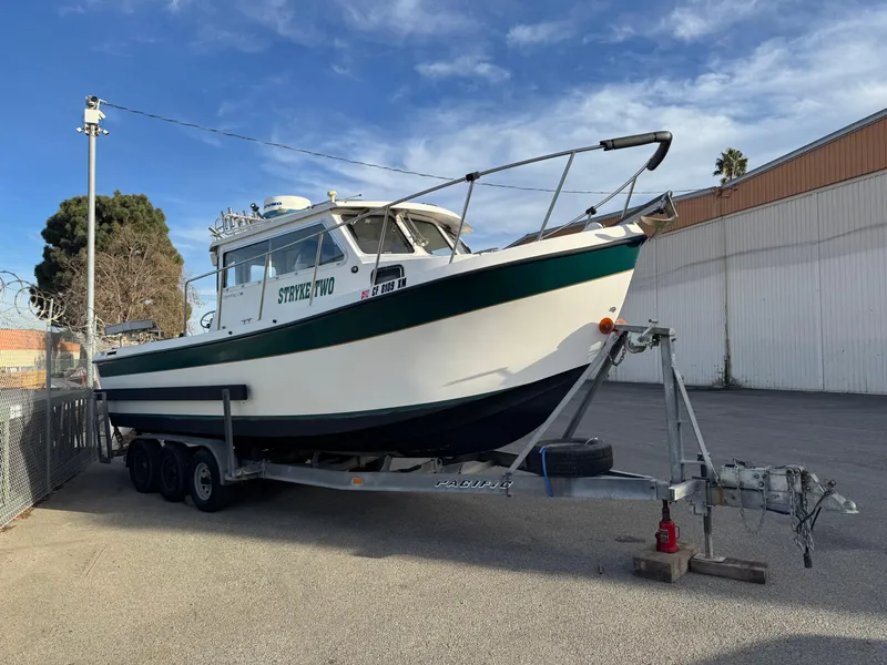 Slide: The Image of 1999 Osprey 26 Legend boat on trailer in parking lot. - 1