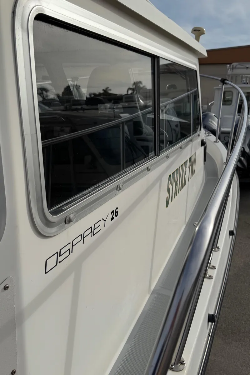 Slide: The Image of 1999 Osprey 26 Legend boat with sleek design and reflective windows. - 12
