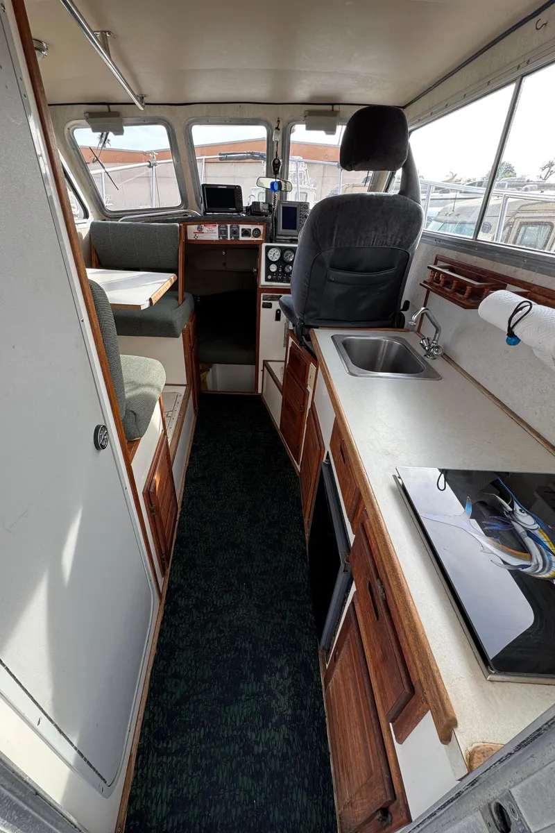 Slide: The Image of Interior of 1999 Osprey 26 Legend boat with kitchen and seating area. - 18