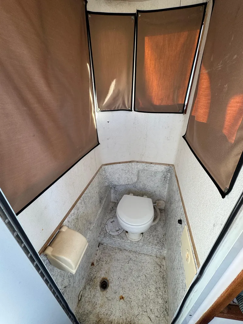 Slide: The Image of 1999 Osprey 26 Legend boat bathroom with toilet and privacy curtains. - 3