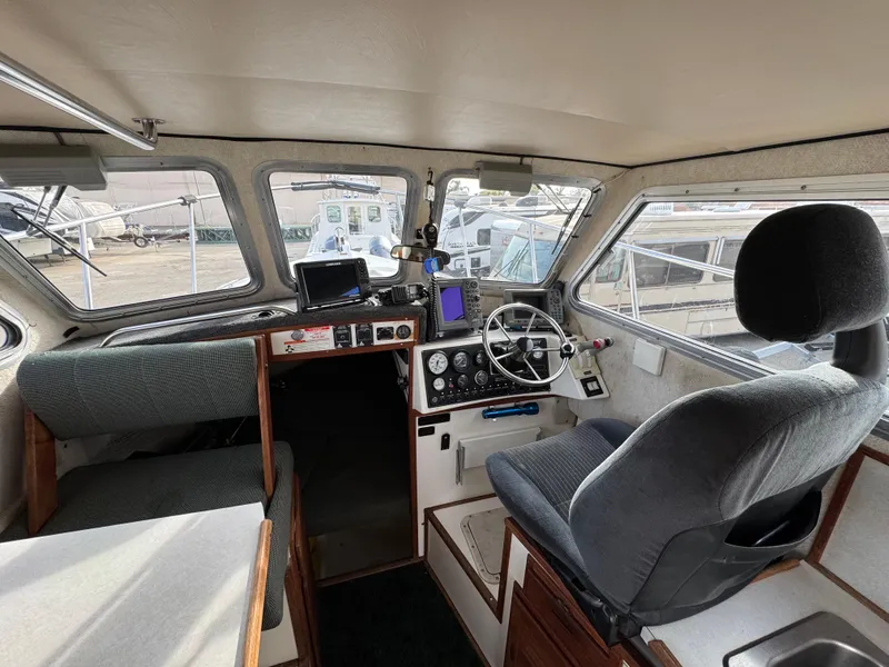 Slide: The Image of Interior of 1999 Osprey 26 Legend boat with steering wheel and navigation equipment. - 9