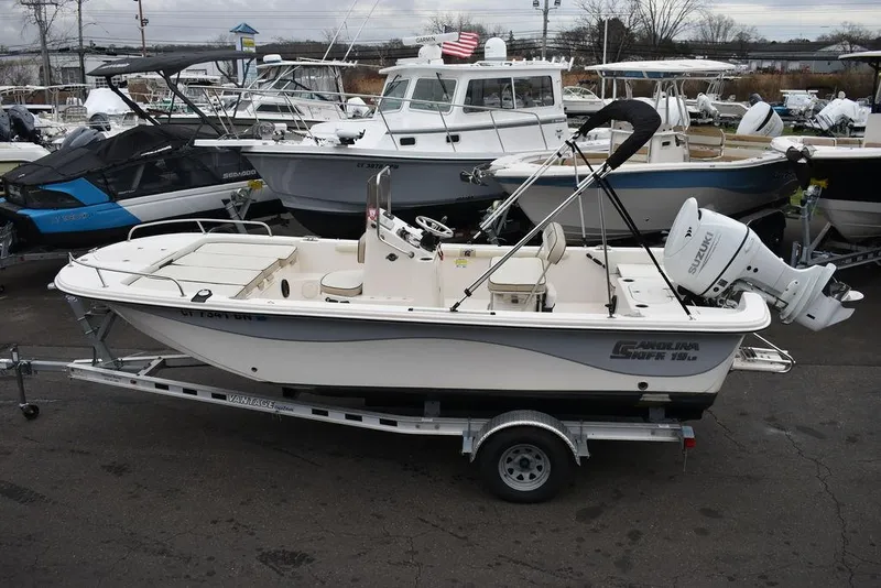 Slide: The Image of 2022 Carolina Skiff 19 LS boat on trailer, surrounded by other boats in a marina. - 6