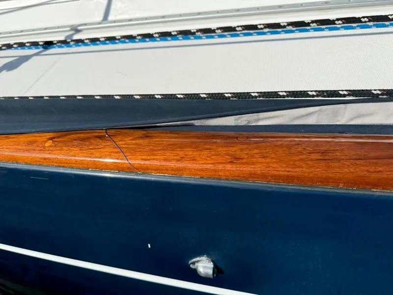 Slide: The Image of Close-up of 2004 Beneteau Oceanis Clipper 473 with polished wood and sleek blue hull. - 10