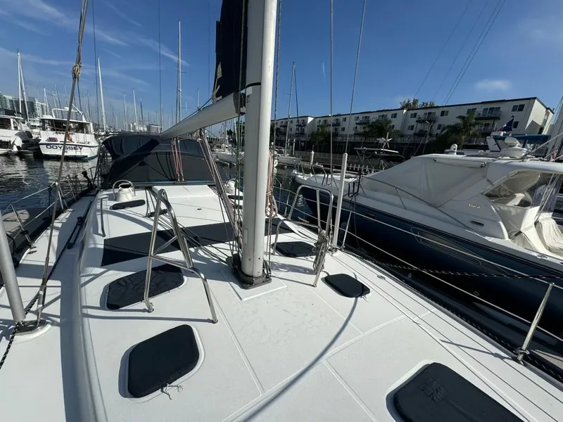 Slide: The Image of 2004 Beneteau Oceanis Clipper 473 sailboat docked in a marina under clear skies. - 11