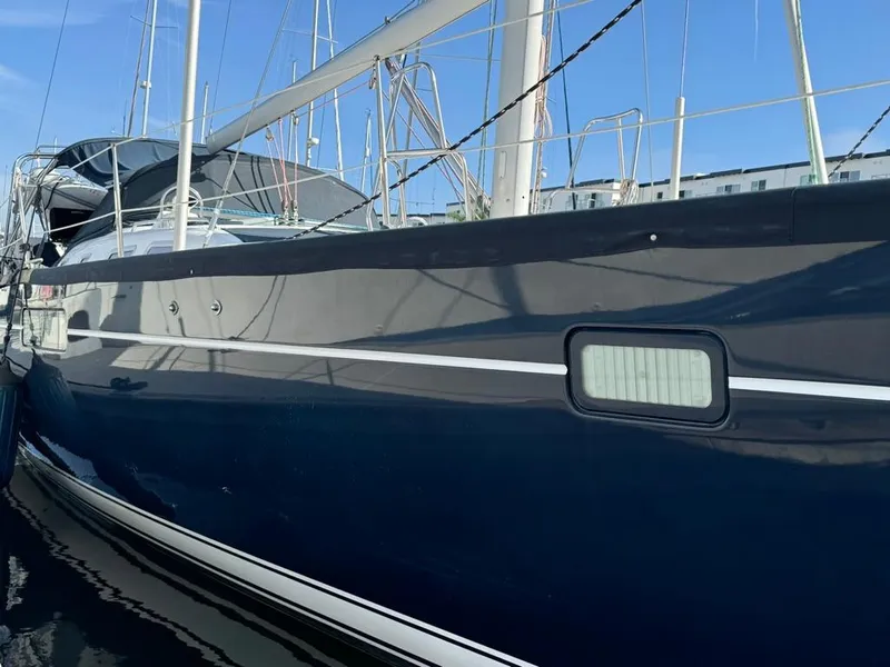 Slide: The Image of 2004 Beneteau Oceanis Clipper 473 sailboat docked, side view with blue hull. - 12