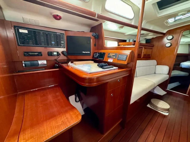 Slide: The Image of Interior of 2004 Beneteau Oceanis Clipper 473 yacht, featuring navigation station and seating area. - 21