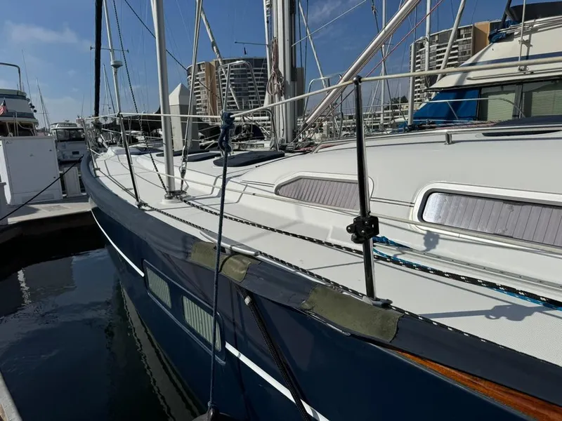 Slide: The Image of Beneteau Oceanis Clipper 473, 2004 model, docked at marina with clear blue sky. - 3