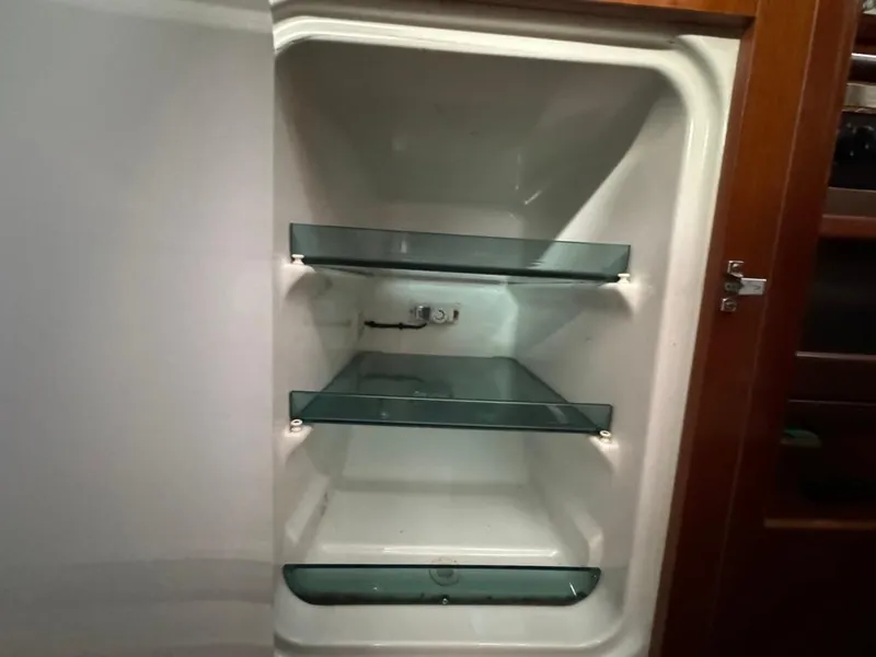 Slide: The Image of Empty refrigerator with glass shelves on a 2004 Beneteau Oceanis Clipper 473 yacht. - 31