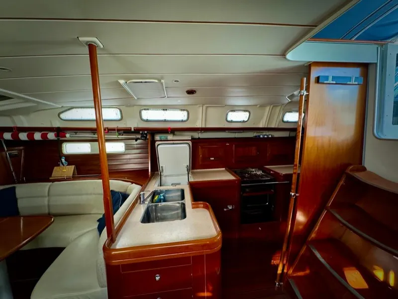 Slide: The Image of Interior of 2004 Beneteau Oceanis Clipper 473 yacht, featuring kitchen and seating area. - 38